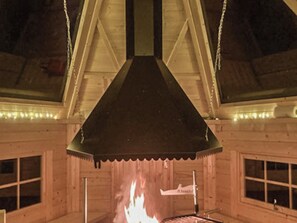 Un interior de madera con chimenea, ventanas y una chimada.