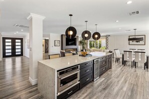 A modern kitchen with a central island, built-in ovens, and pendant lighting. - SWSS 4BR Kierland Luxury Escape | Heated Pool, Hot Tub, Putting Green, Game Room, Pickleball (Scottsdale)