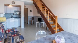 Ein gemütliches Apartment mit Küche, Essbereich und einer Treppe.