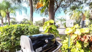 A vehicle parked in a lush, green area with dense foliage and trees in the background.