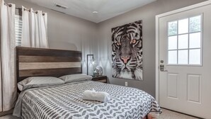 A bedroom with a bed, a tiger mural, a door, and a window. - Heart of Atlanta 4BR Home – 1 Block to Beltline & Krog Street Market (Atlanta)
