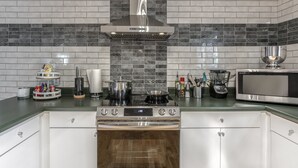 A modern kitchen with a stainless steel stove, a microwave, and a large pot on the counter. - Heart of Atlanta 4BR Home – 1 Block to Beltline & Krog Street Market (Atlanta)