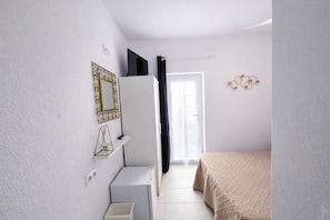 A bedroom with a bed, a dresser, a mirror, and a door leading to a balcony. - Cañaveral Playa Conil II Room - right on the beach (Conil de la Frontera)