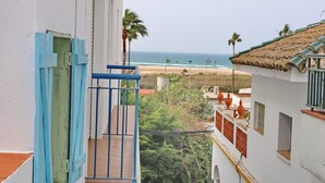 Ein Balkon mit Blick auf Strand und Meer.