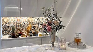 Eine moderne Küche mit Marmorarbeitsplatte, einer dekorativen Vase mit Blumen und einer Obstschale.