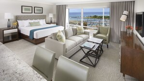 A hotel room with a bed, a sofa, a coffee table, a TV, and a balcony with a view of the ocean. - Ilikai Sunset Ocean View Studio Steps from Waikiki Beach Attractions (Honolulu)