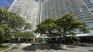 A high-rise hotel with multiple balconies and a central vertical feature. - Ilikai Sunset Ocean View Studio Steps from Waikiki Beach Attractions (Honolulu)