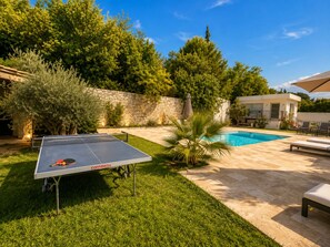 A poolside area with a ping pong table, a stone wall, and a pool. -  Luxury villa in Aix en Provence, with 2 private accommodation  (Aix-en-Provence)