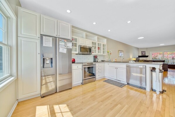 Enjoy cooking in this well-equipped kitchen with appliances, a large island, and a window for natural light.