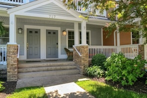 Steps lead to the front door of this charming home, surrounded by a lush garden and a tranquil atmosphere.