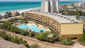 Un hôtel doté d’une piscine, offrant une vue sur la plage et comprenant plusieurs balcons.