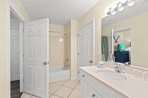 Ein Badezimmer mit einem Doppelwaschbecken, einem großen Spiegel und einer Dusche.