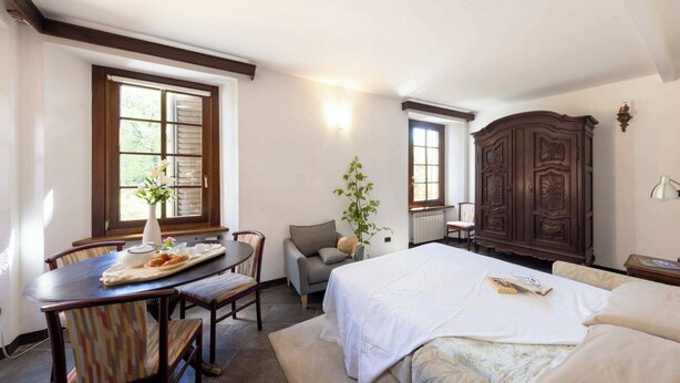 Ein Schlafzimmer mit einem Bett, einem Schreibtisch mit Stuhl, einem Schrank und einem Fenster.