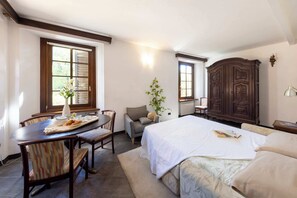 Une chambre à coucher avec un lit, un bureau avec une chaise, une armoire et une fenêtre.