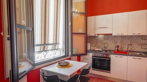 Une cuisine compacte avec un coin repas, comprenant une fenêtre, une cuisinière et un évier.