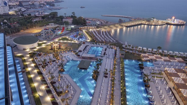 Ein Resort mit mehreren Swimmingpools, Liegestühlen und einem Jachthafen.