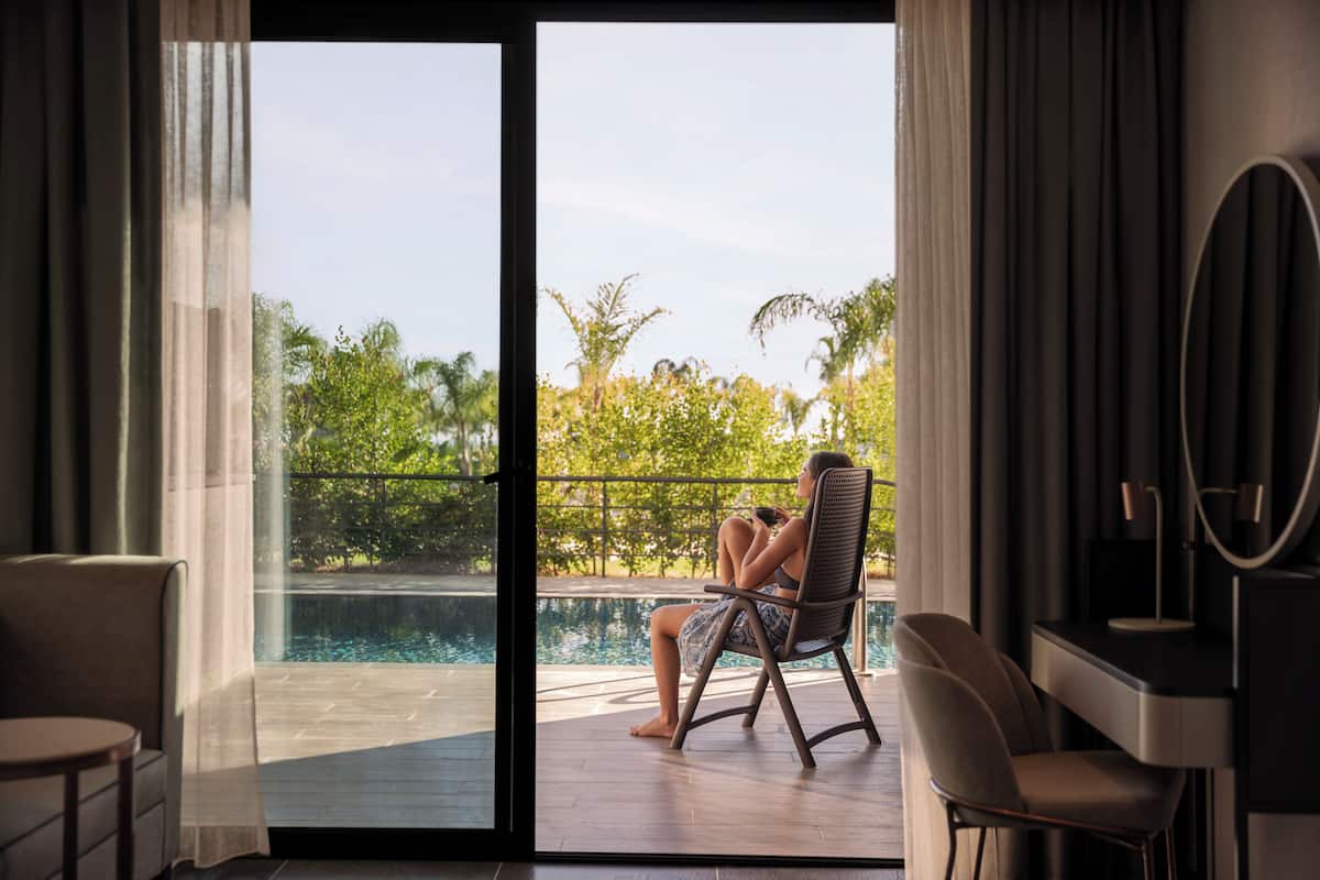 Ein Zimmer mit Blick auf einen Swimmingpool, einen Stuhl und einen Tisch.