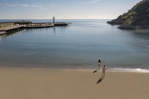 Una playa con un muelle y un faro.