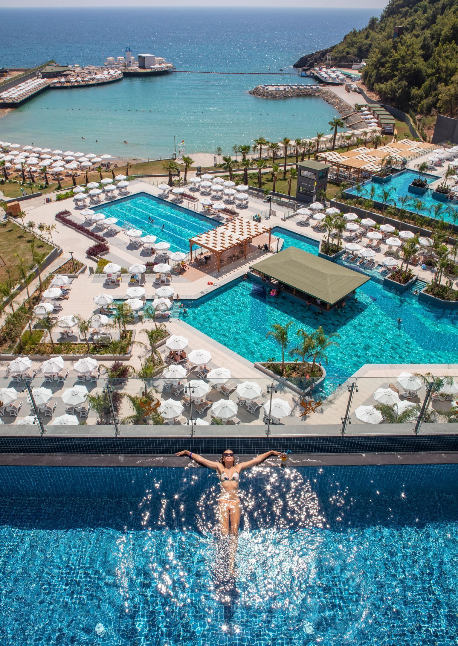 Een resort met diverse zwembaden, ligbedden en parasols.