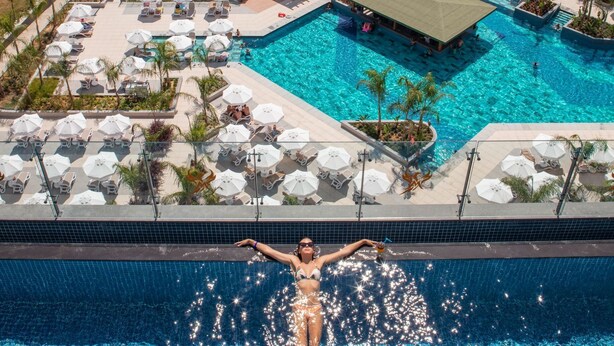 Un resort con varias piscinas, tumbonas y sombrillas.