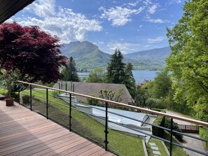 A balcony with a view of a lake, mountains, and a forested area. - Villa (Talloires-Montmin)