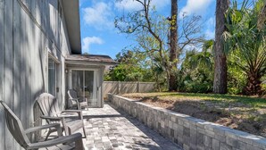 Un patio con mobiliario exterior y vistas a una casa.