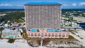 A high-rise hotel with multiple floors, a pool area, and a beach view. - Sunrise Beach 1611 Gulf Front Corner Condo Sleeps 10 (Panama City Beach)