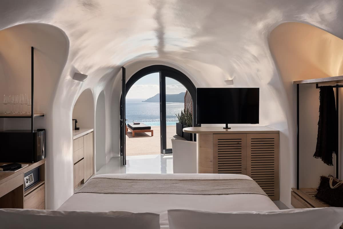 Ein Schlafzimmer mit einem großen Bett, einem Fernseher und Meerblick.