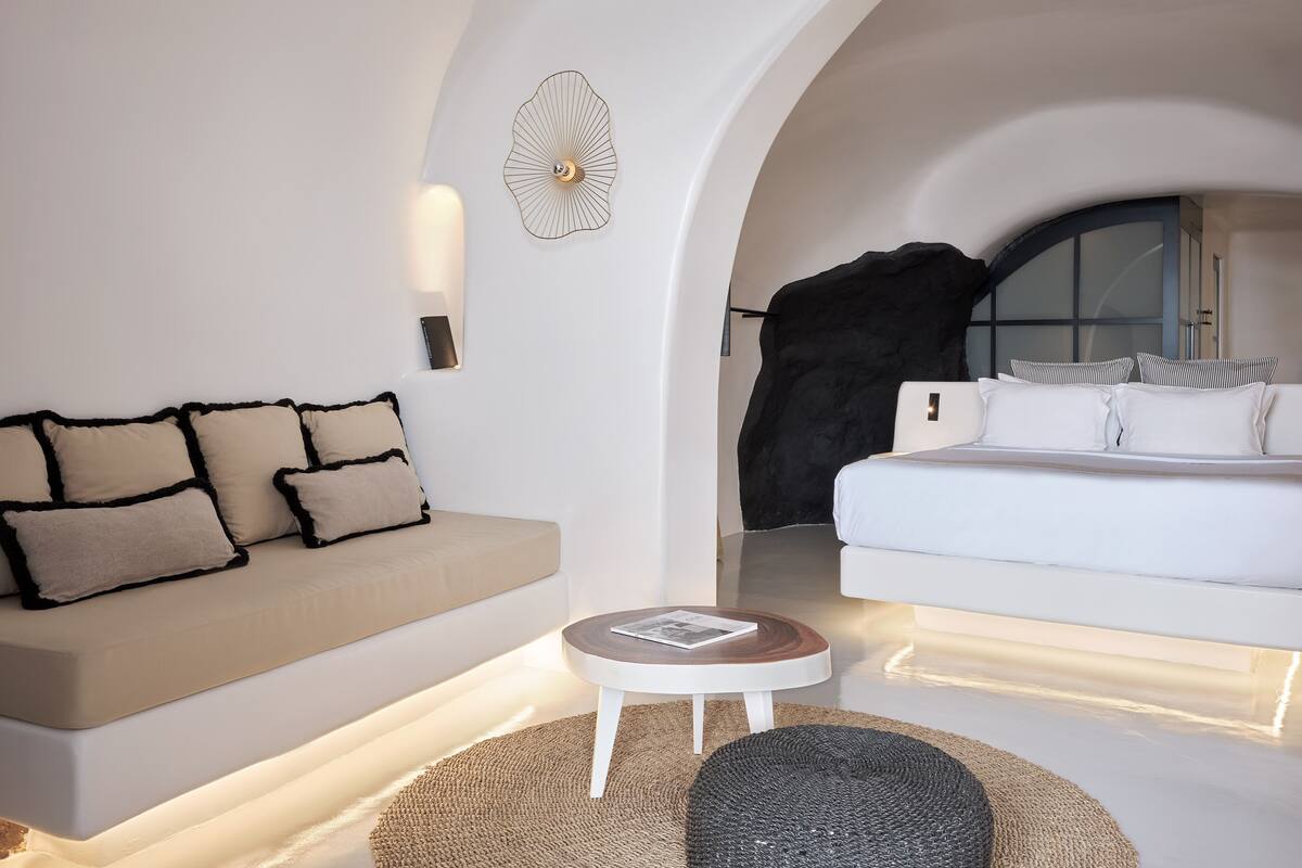 Ein modernes Schlafzimmer mit einer Couch, einem Bett und einem kleinen Tisch.