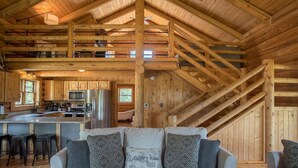 A log cabin interior with a kitchen, dining area, and a staircase. - Remote Mountain Cabin with Incredible Views (Superior)