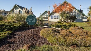 Een bordje voor Chalet Village met een landelijk gebouw op de achtergrond.