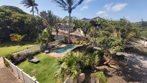 A residential area with a swimming pool, lush greenery, and a white fence. - Crayfish Inn no.5 (Margate)
