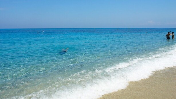 A beach with clear blue water and a sandy shore. - House (Tropea)
