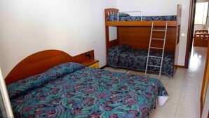 A room with two bunk beds, a wooden headboard, and a ladder. - House (Tropea)