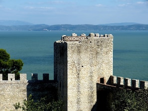 A stone tower with battlements overlooking a body of water.
