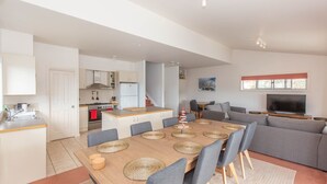 A modern apartment with a kitchen, dining area, and living room. - Reedy's Run - 11 Reedy's Cutting (Jindabyne)