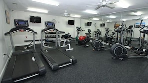 Uma academia com esteiras, elípticos e equipamentos de musculação.