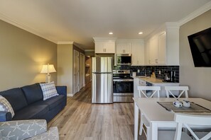 Cozy living area with a kitchenette, sofa, and flat-screen TV.