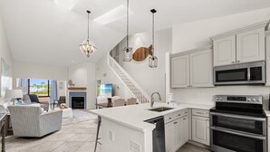 A modern kitchen with white cabinetry, stainless steel appliances, and a central island.