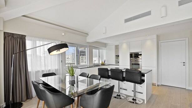 A modern kitchen with white cabinets, a black countertop, and a built-in oven.