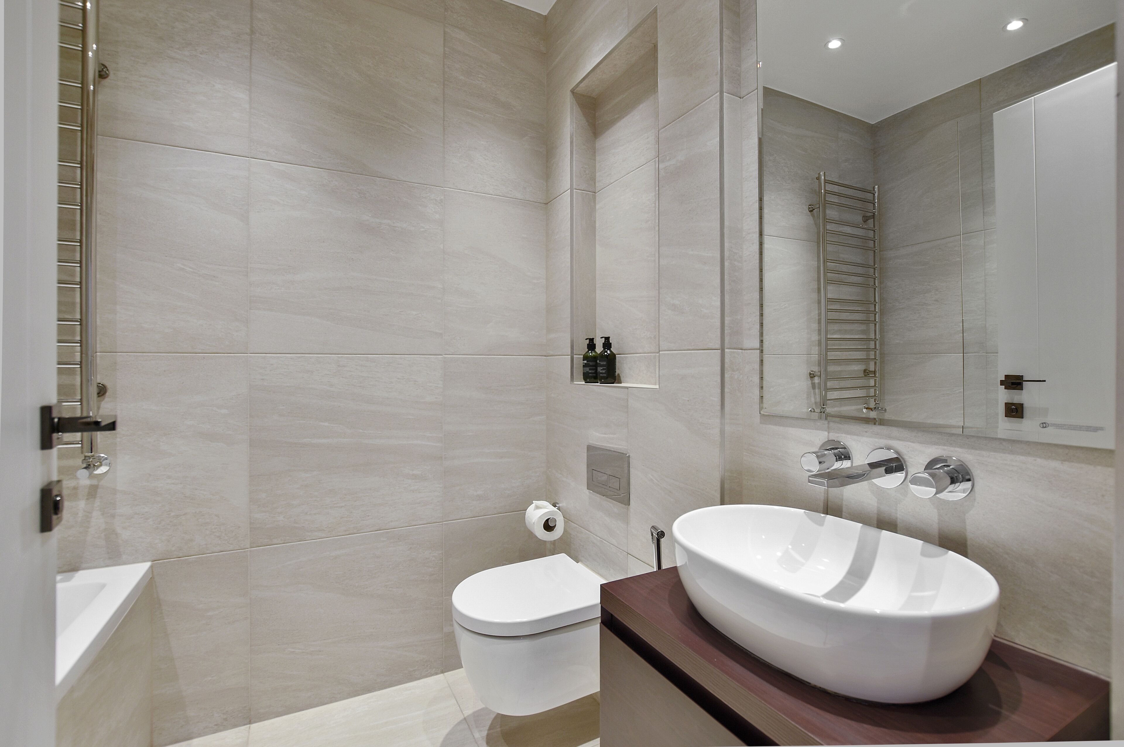 Un baño moderno con bañera, inodoro y un lavabo grande.