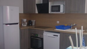A compact kitchen with a refrigerator, microwave, coffee maker, and dishwasher. - T3 2nd floor of the villa of the sea (Hyères)
