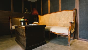 Classic design features a bench, chest of drawers, and a table with a lamp and fruit.