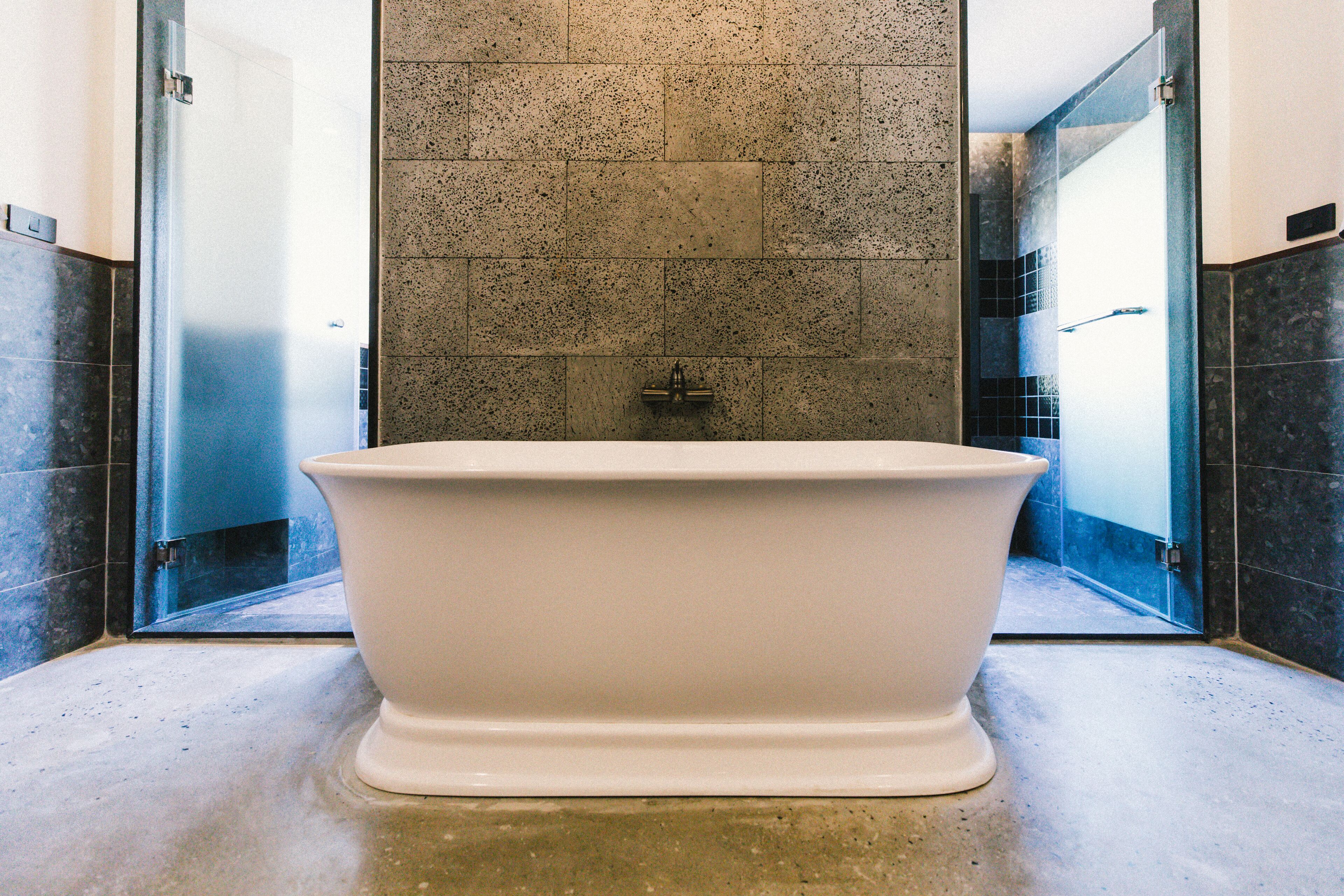 A modern bathroom with a freestanding bathtub, tiled walls, and a glass shower enclosure.