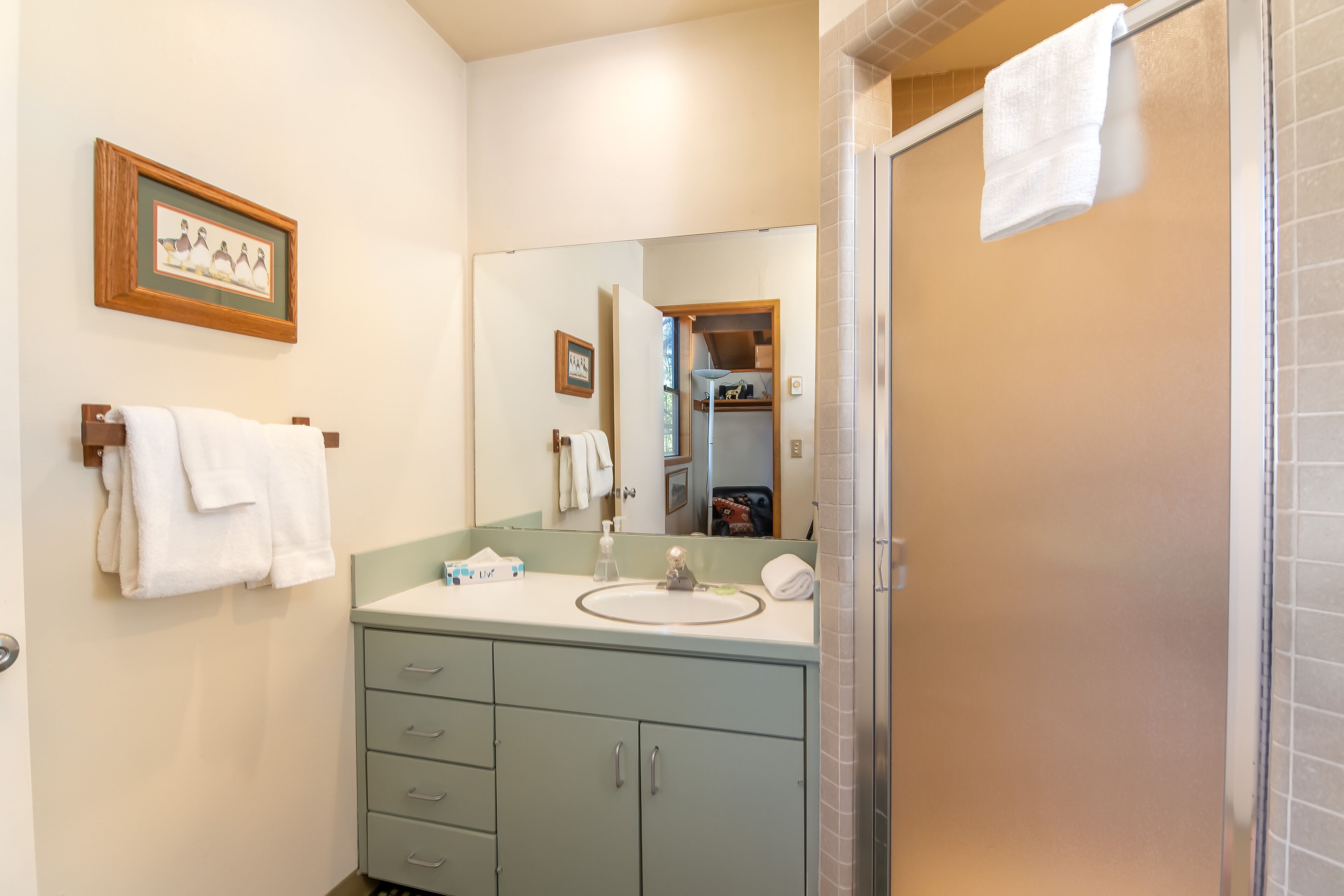 Une salle de bain avec un lavabo, un miroir et un porte-serviettes.