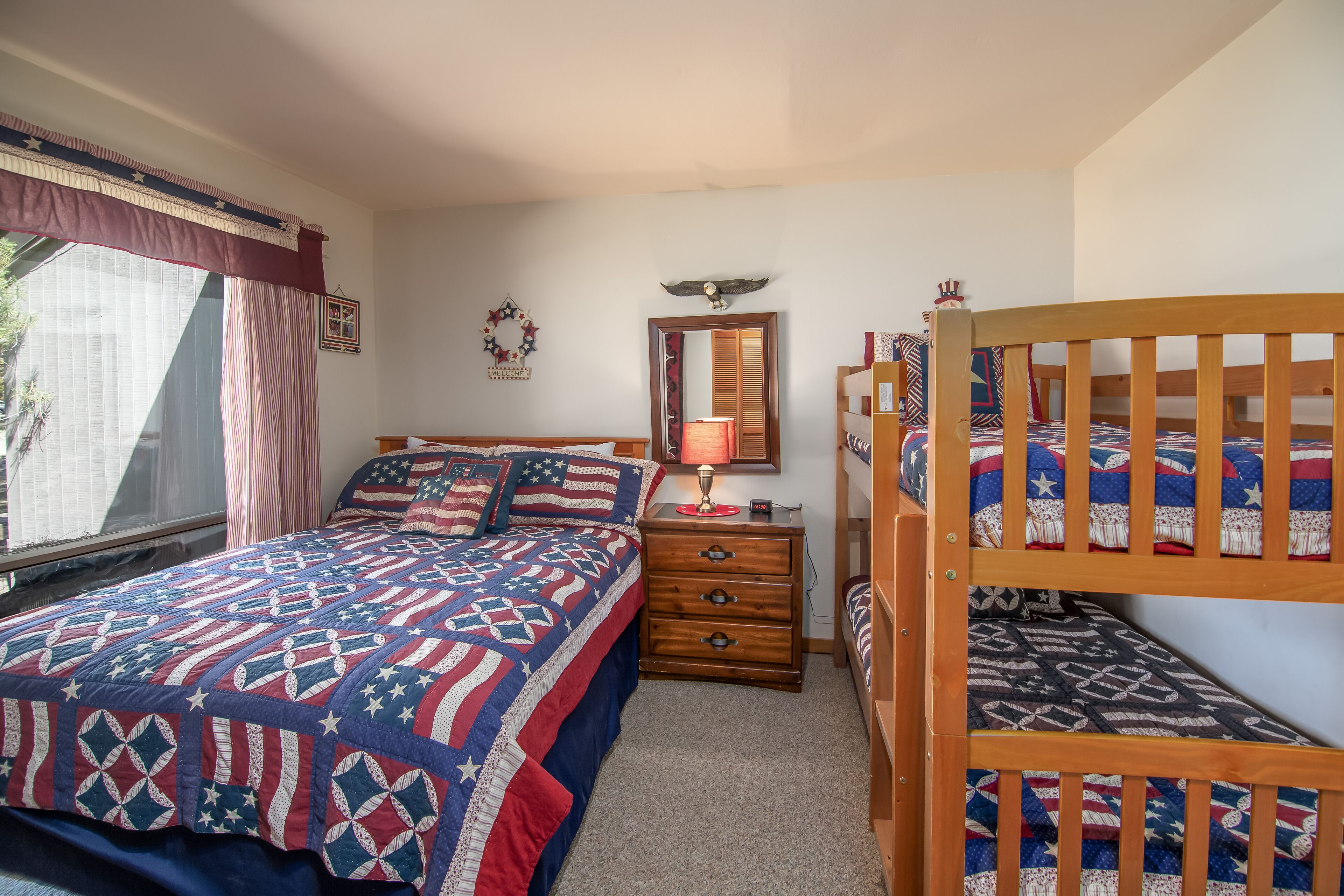A bedroom with a bed, a dresser, a mirror, and a bunk bed.