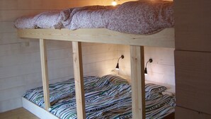 Un lit superposé avec une couette à motifs floraux et un lit inférieur avec une couette à rayures.