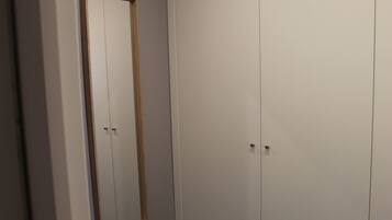 A room with a large wardrobe and a mirror.