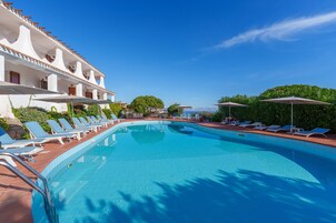 Una piscina al aire libre de temporada, sombrillas, tumbonas