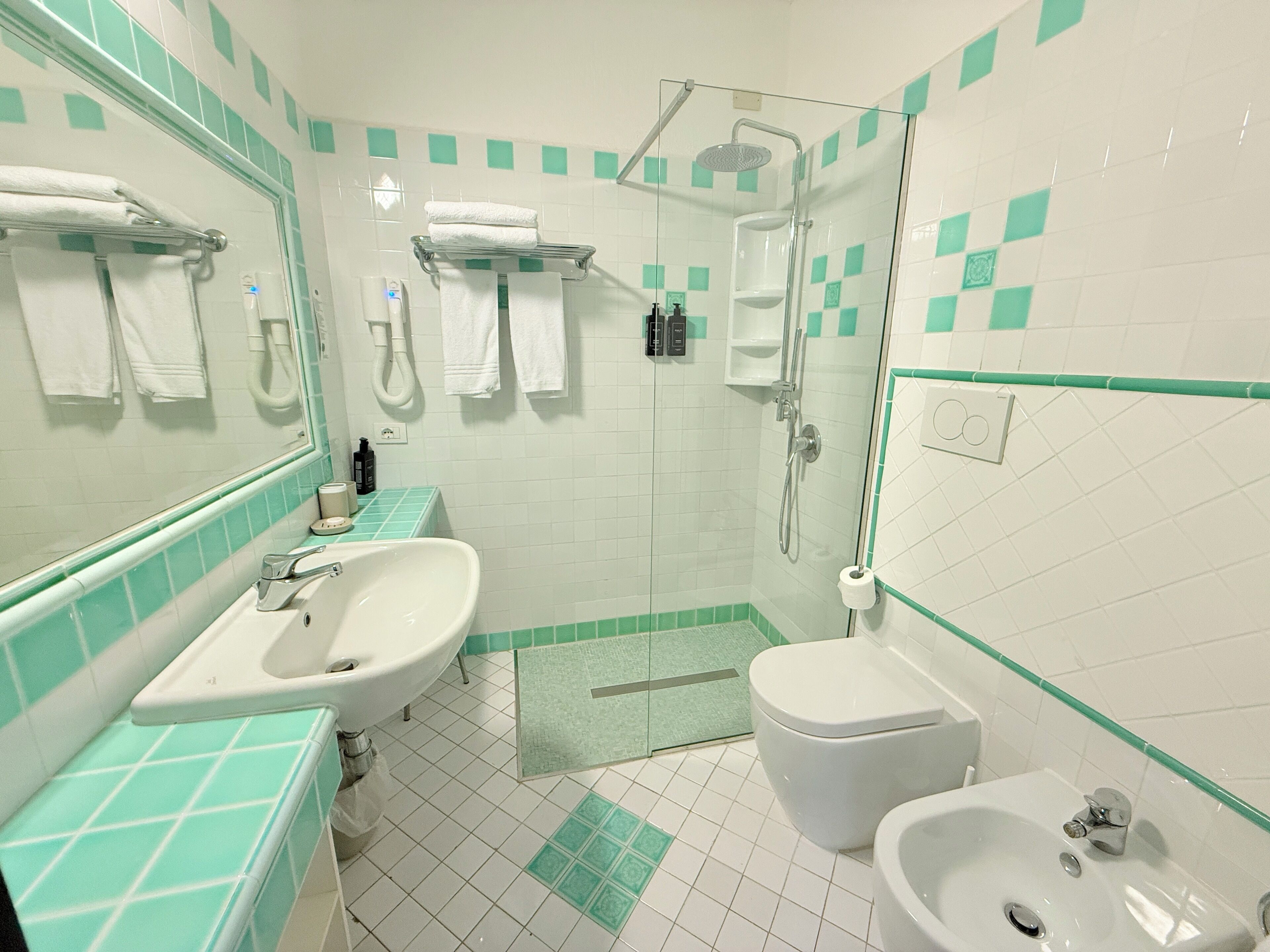 A bathroom with a sink, toilet, and shower.